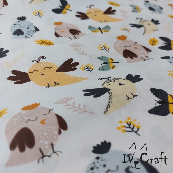 Kokvilnas audums ar pūcēm un tauriņiem uz balta fona